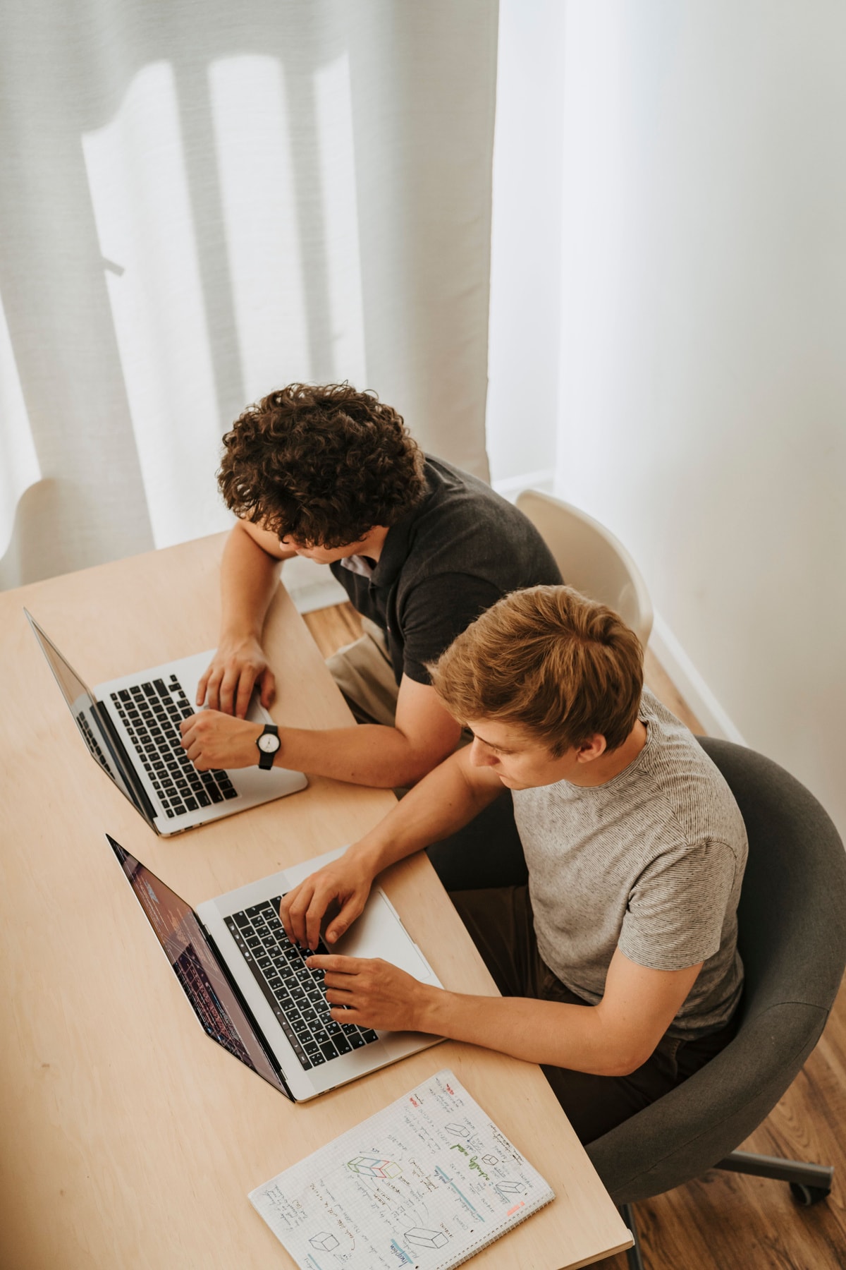 Two Synergy developers working side by side at a shared desk