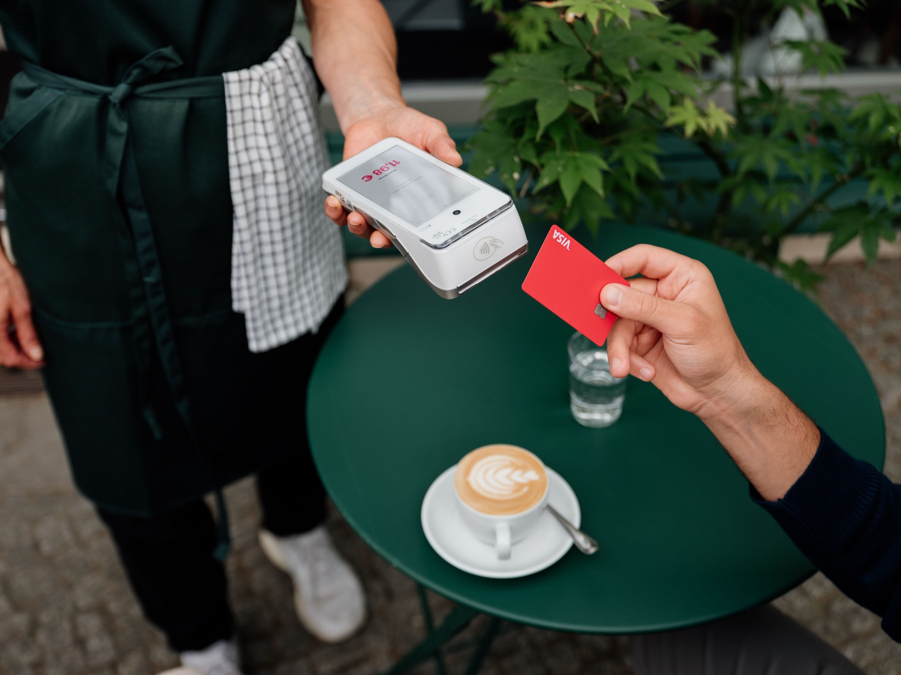 A customer paying by card at a café table