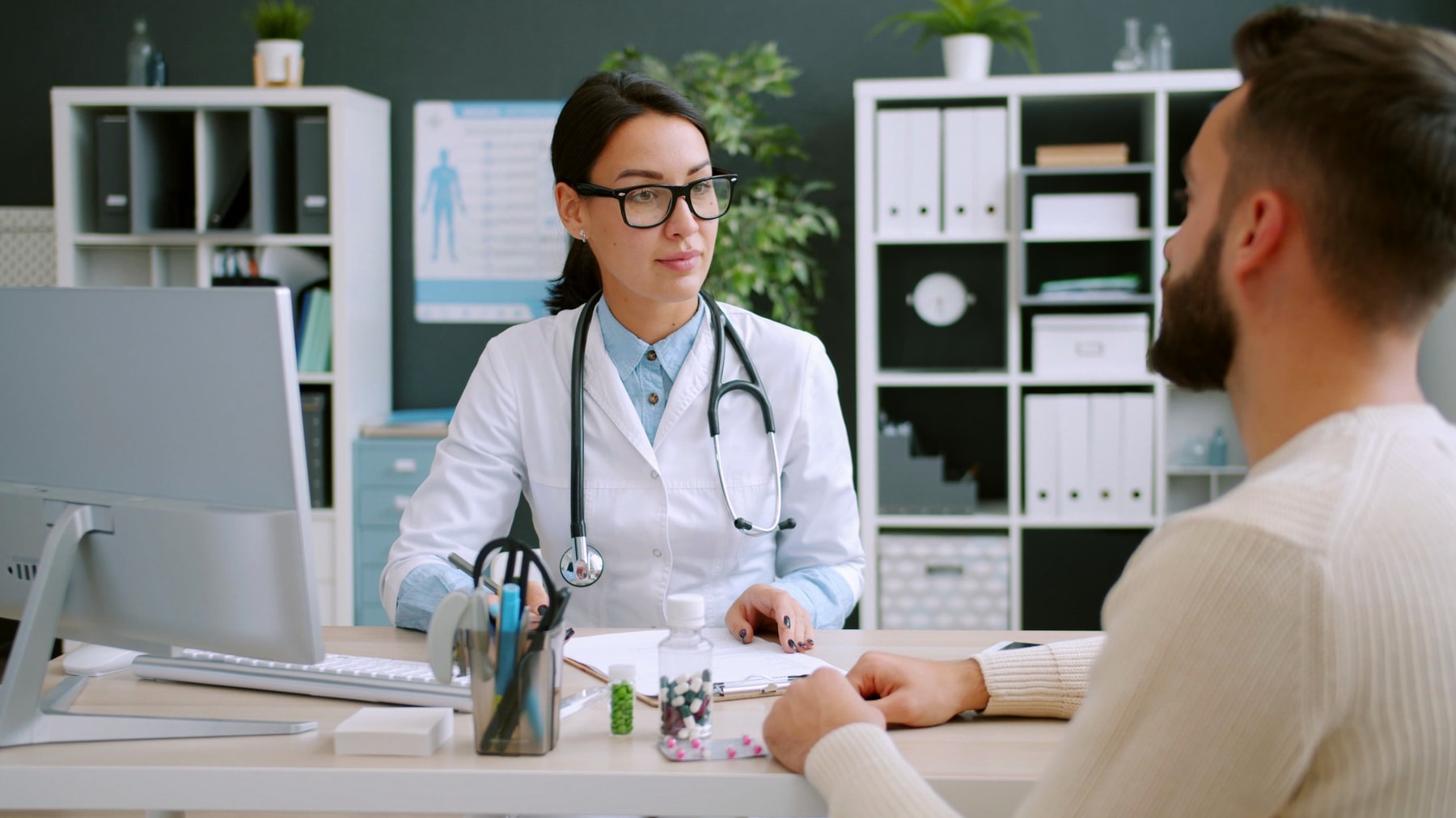 A doctor talking with a patient across her desk
